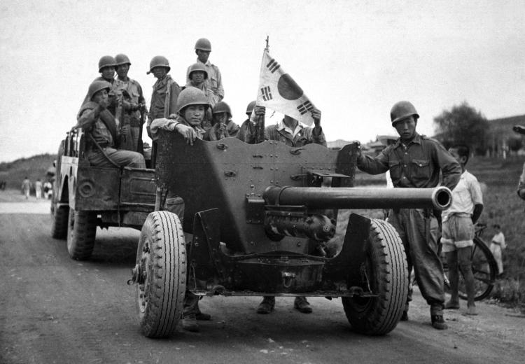 During South Korean evacuation of Suwon Airfield, a 37-mm anti-tank gun is hauled out of the area for repairs, by a weapons carrier. 1950