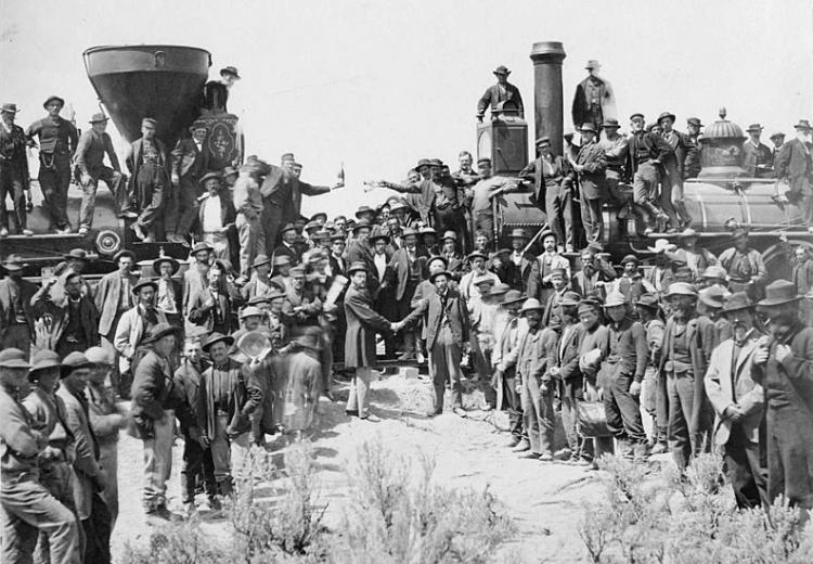 The ceremony for the driving of the golden spike at Promontory Summit, Utah on May 10, 1869; completion of the First Transcontinental Railroad. At center left, Samuel S. Montague, Central Pacific Railroad, shakes hands with Grenville M. Dodge, Union Pacific Railroad (center right).