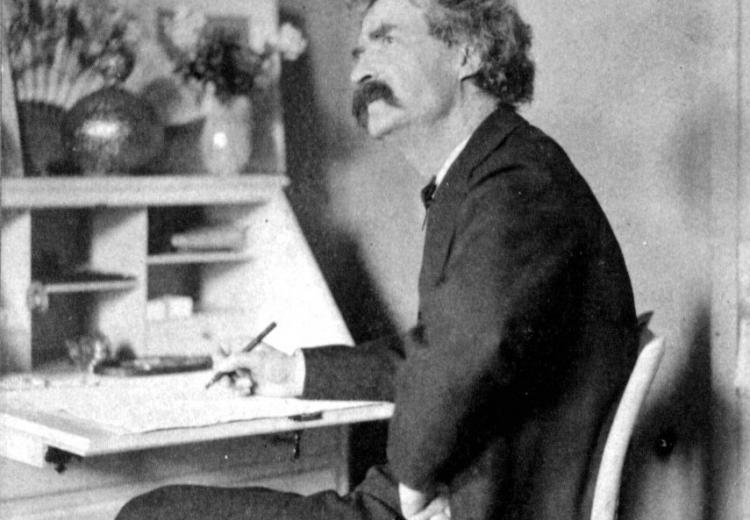 Mark Twain, pondering at his desk. c. 1890