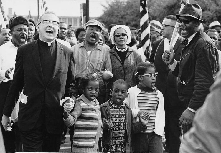 Black and white photo of three children and many adults in civil rights march