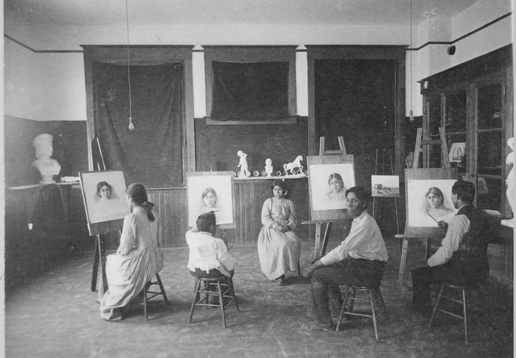 Students with easels and seated model