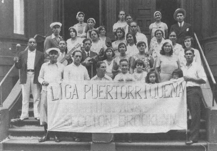 Early Puerto Rican immigrants in New York City, assembled on staircase, holding banner