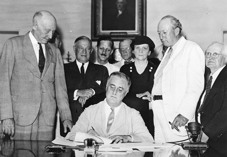Franklin D. Roosevelt signing the Social Security Act, August 14, 1935.