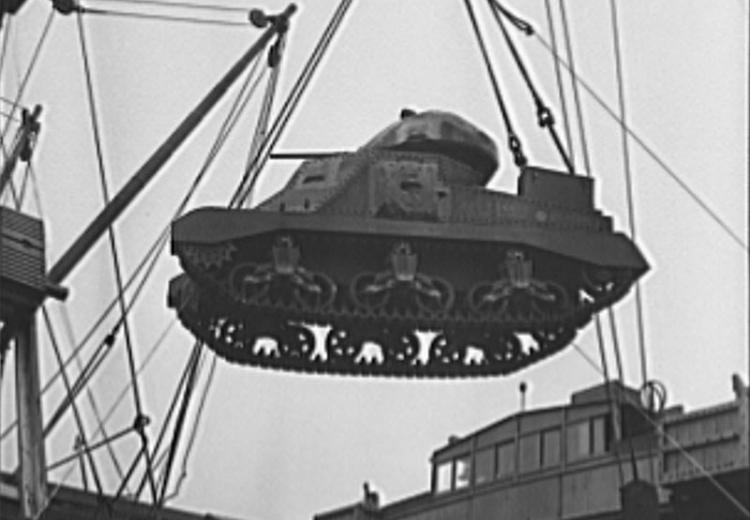 A lend-lease tank coming over the side of a cargo ship in a United States Atlantic Coast port.