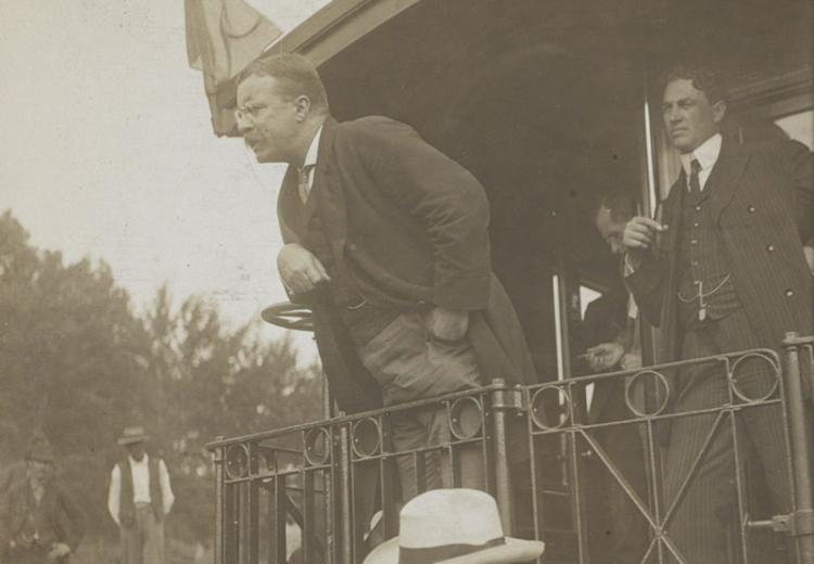 Teddy Roosevelt speaking at the back of a railroad car.